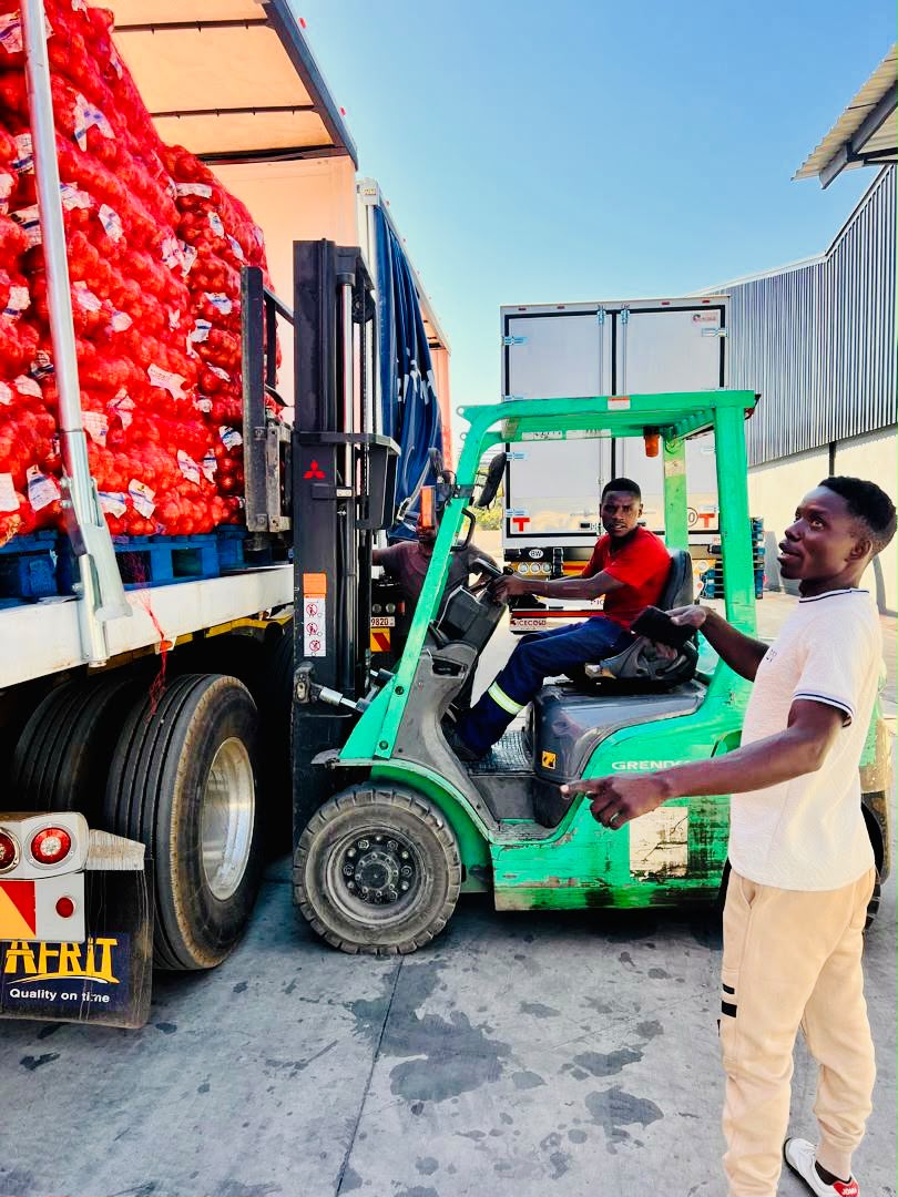 Forklift loading bags of onions onto a truck